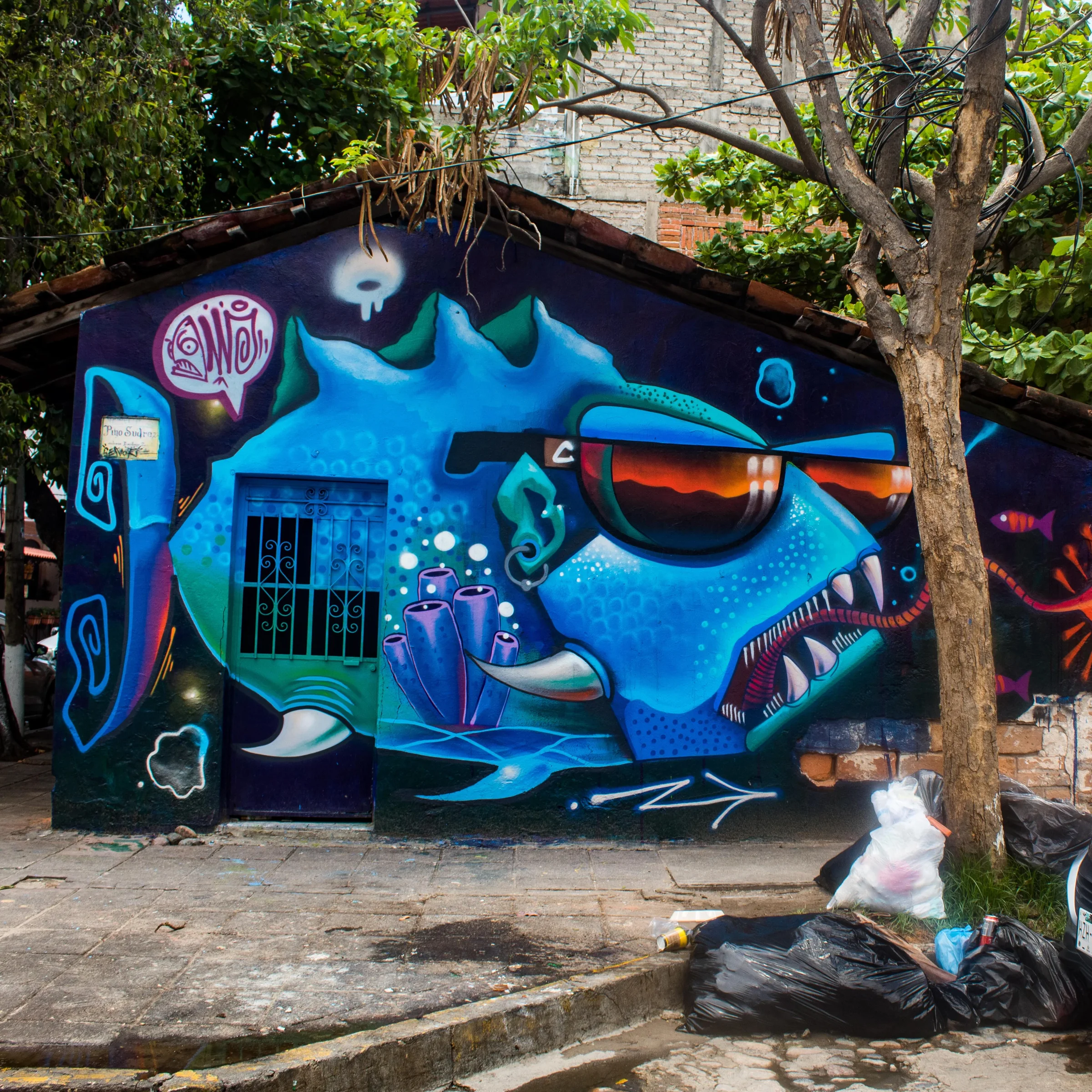 A large blue reef fish mural painted across the wall of a street-corner building