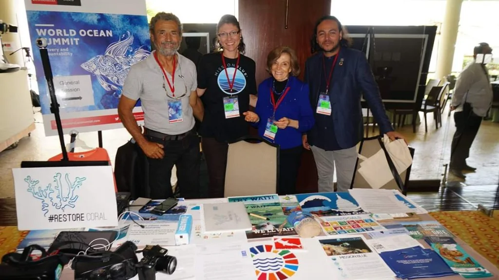 Restore Coral representatives at an ocean summit stand with campaign materials