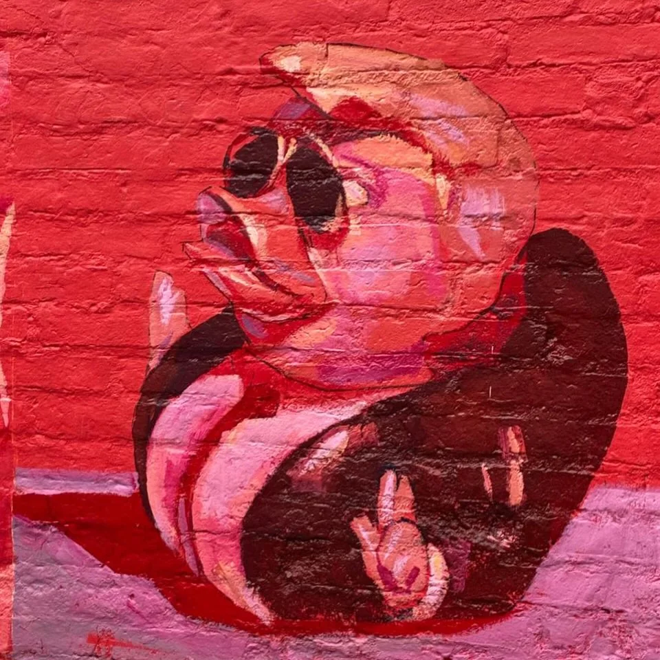 Detail of a red mural panel painted on brick