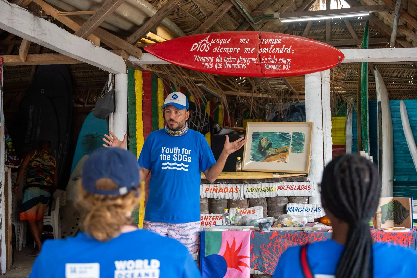 A Restore Coral facilitator speaking with a community group in a beachside palapa